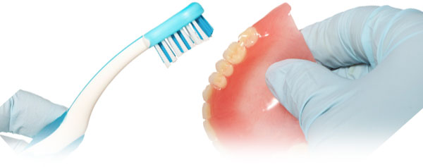 Photo: brossage d'une prothèse avec une brosse à dents